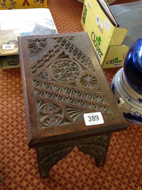 An Arts & Crafts carved hardwood small Eastern style stool, inscribed to base S. Martins.