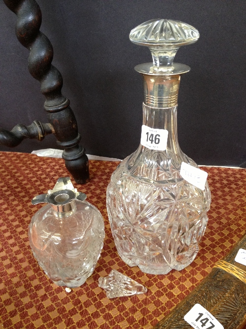 A silver topped decanter together with a silver topped scent bottle.