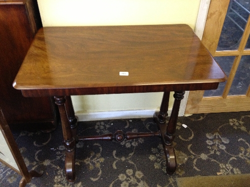 A small mahogany side table on turned supports with cross stretcher.