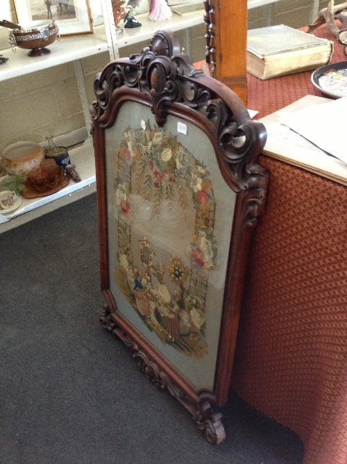 A large 19th century wool work picture depicting Three Young Girls hanging a picture beneath a