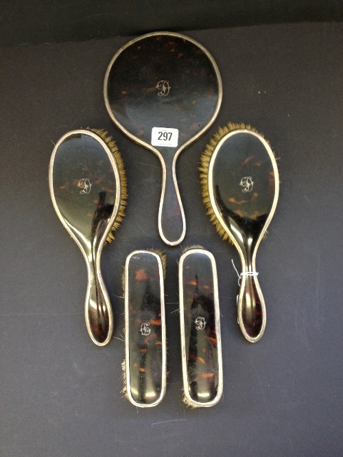 An early 20th century five piece tortoiseshell and silver dressing table mirror and brush set.