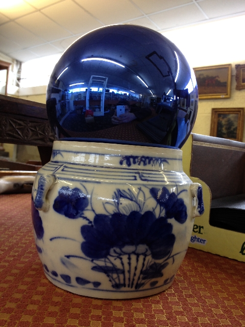 A blue glass Witches` ball together with a Chinese blue and white vase.