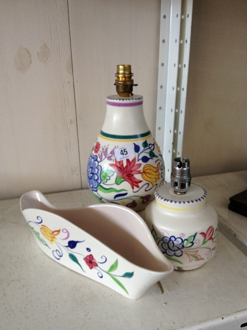 Two Poole Pottery white bodied lamp bases decorated in traditional patterns together with a flower