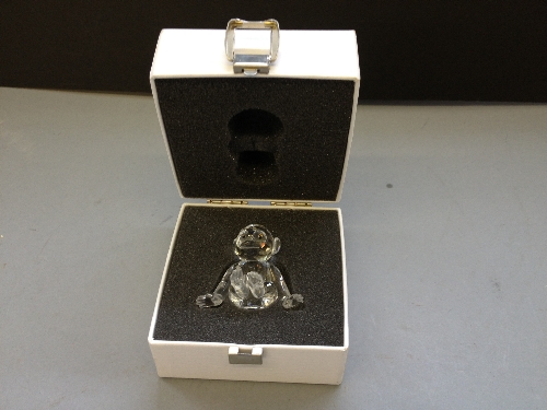 A Swarovski crystal glass model of a chimp in original box.