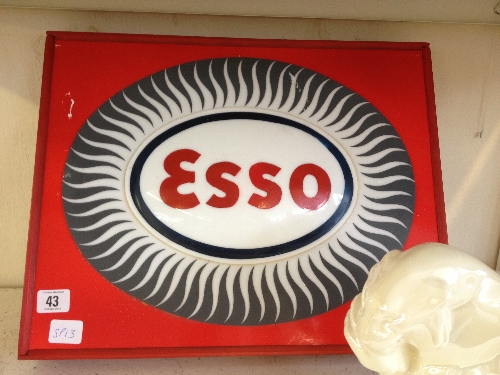 A perspex Esso petrol sign mounted on wooden board.