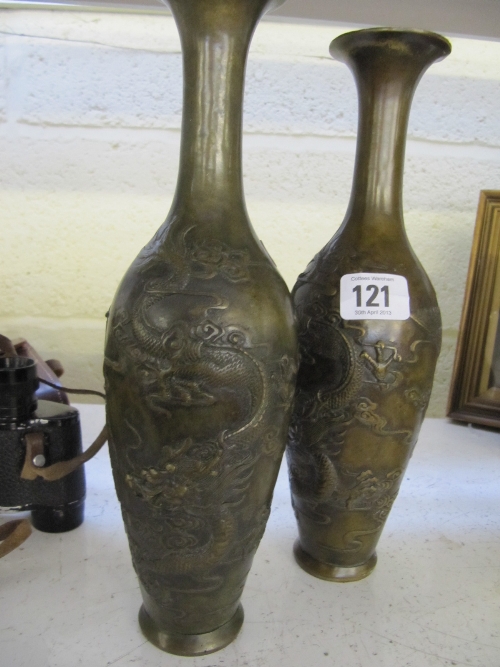 A pair of Chinese bronze bottle shaped vases decorated with dragons.