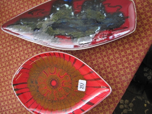 A Poole Pottery Delphis dish decorated in an abstract pattern on red ground together with a spear