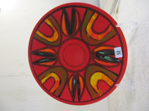 A Poole Pottery Delphis dish, shape 5, decorated in an abstract pattern on red ground.