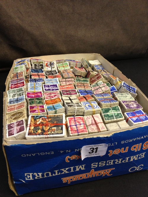 A box containing a large quantity of bundles of British postage stamps.