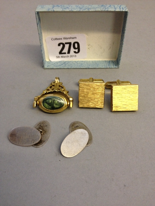 A pair of silver cuff-links marked 535 and a gold coloured fob.