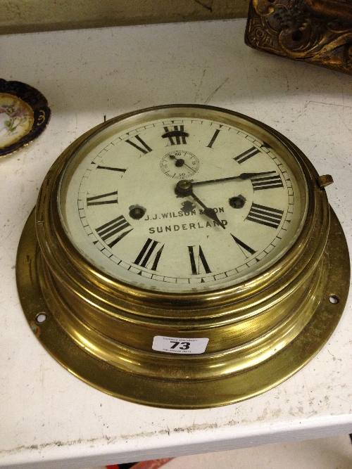 An early 20th century circular brass ship`s clock with secondary dial, inscribed J J Wilson & Son,