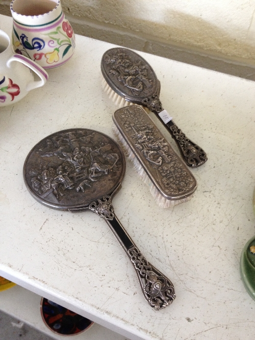 A Continental silver metal brush and mirror set together with a similar brush.