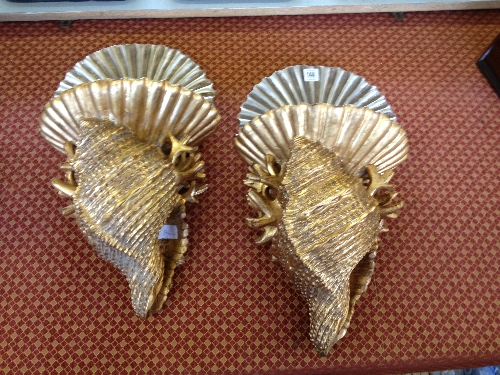 A pair of shell shaped gilt wood wall shelves.