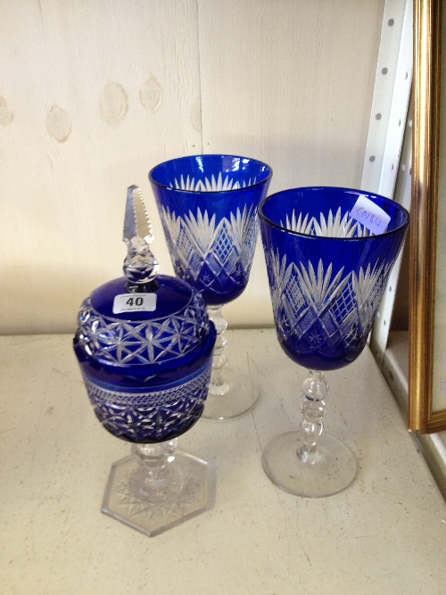 A pair of blue cut glass Bohemian style large goblets together with a similar jar and cover.