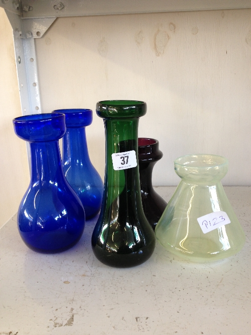 Five various coloured glass bulb vases including a squat shaped Vaseline glass bulb vase.