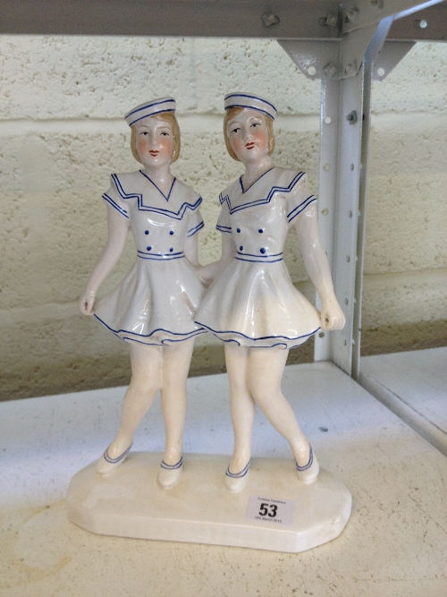 An Art Deco style china ornament modelled as two young dancing sailor girls.