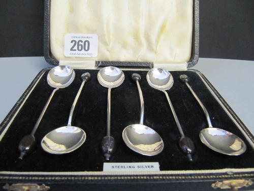 A cased set of six silver teaspoons with bean finials.