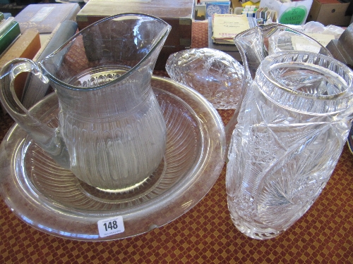 A large glass jug and bowl together with an engraved glass decanter, cut glass vase and water jug.