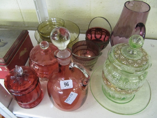 A cranberry glass decanter together with two cranberry glass jars and other coloured glass items.