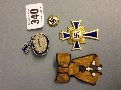 A German Nazi Mother`s badge dated 16th December 1938 to reverse together with a small Swastika