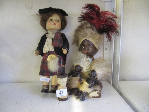 A mid 20th century composition bodied native black doll dressed in traditional fur costume