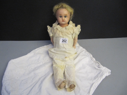 A small 19th century wax head baby boy doll with open eyes on jointed linen body with composition