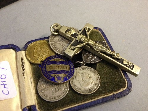 An 1899 silver half Crown together with other coins, badges and a crucifix.