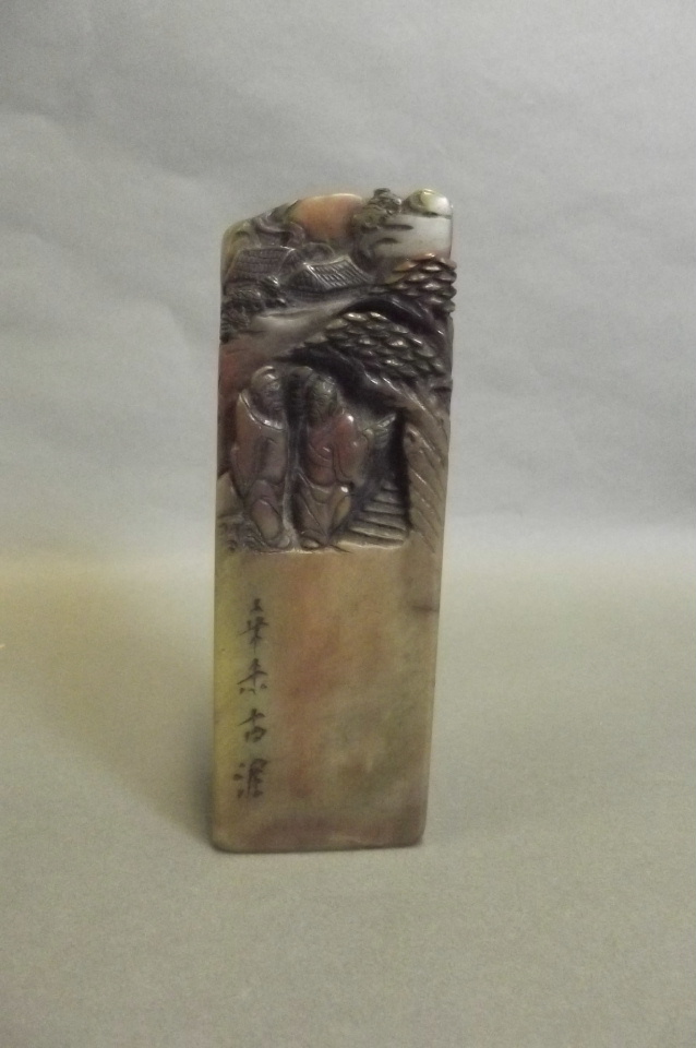 A large Chinese carved soapstone seal decorated with travellers in a mountainous landscape, 6''