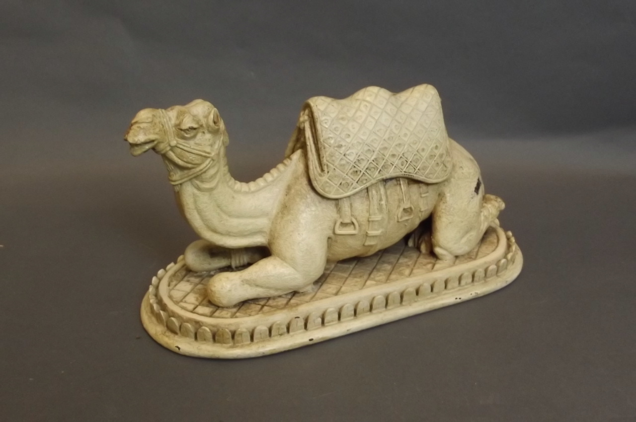 A carved and painted figure of a recumbent camel, 10½'' long