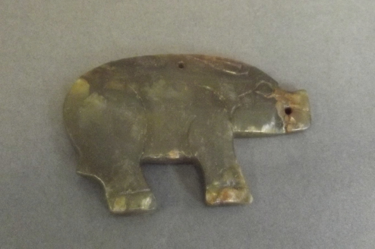 A Chinese jade pendant carved in the form of a pig, 2½'' long