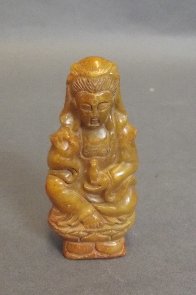 A Chinese hardstone pendant carved in the form of a seated kylin holding a vase, 2¾'' long