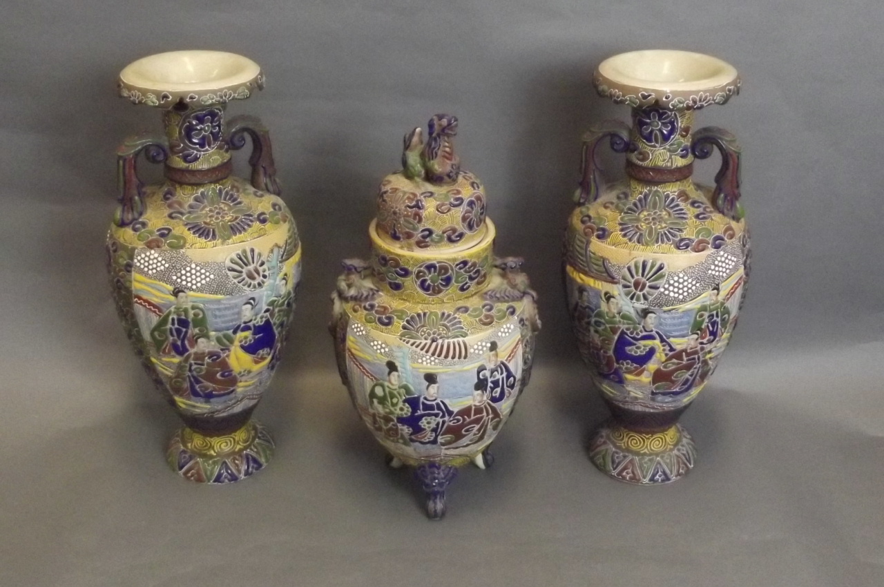 A C19th Japanese Kutani garniture consisting of a pair of twin handled vases, and a jar and cover,