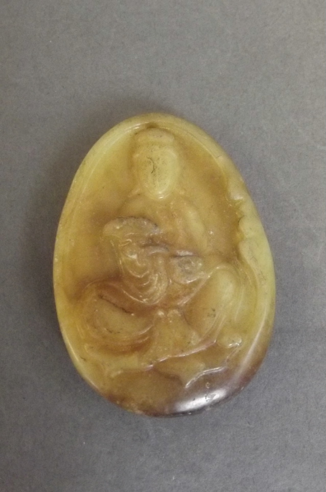 A Chinese mottled yellow and brown pendant carved in the form of a seated kylin, 2'' long