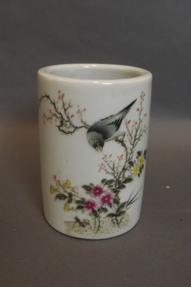 A small Chinese brush pot with painted enamel decoration of a bird perched on a flowering tree,