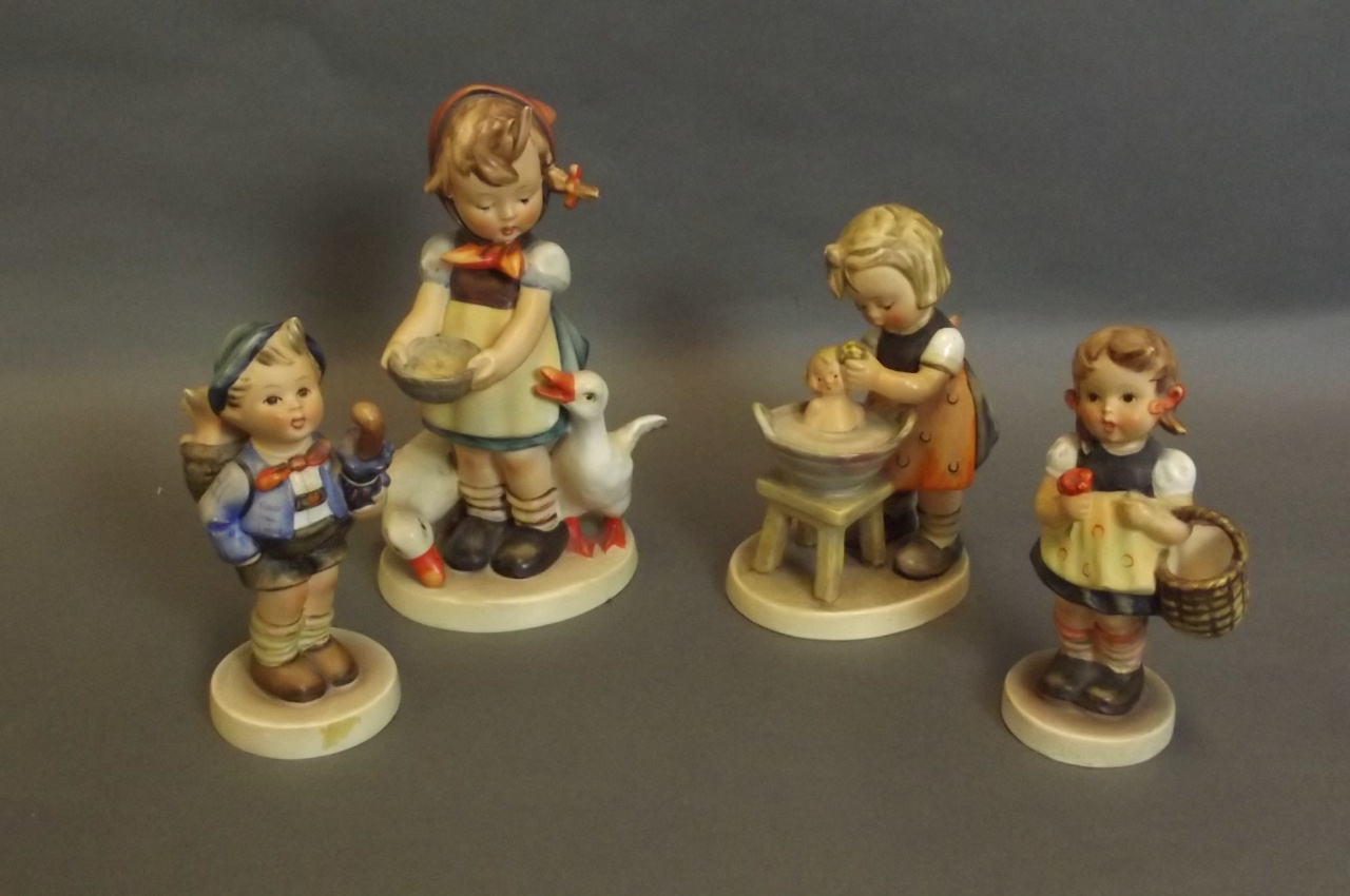 Four Hummel figures to include a girl with geese, a boy with an umbrella and pig, a girl with a