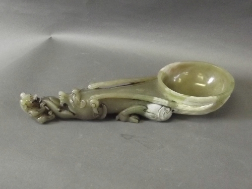 A soapstone ladle carved with a mythical beast handle, 11'' long