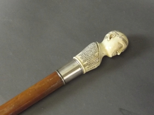 A carved ivory topped walking stick with a Hallmarked silver ferrel, in the form of a Phrenology