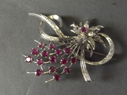 An 18ct white gold ruby and diamond set spray brooch depicting a flower