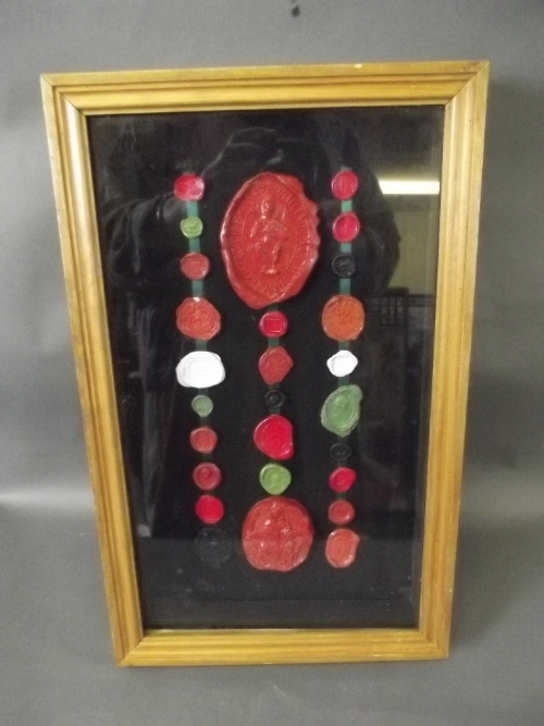 A framed display box containing various wax seals, 15½'' x 9½''