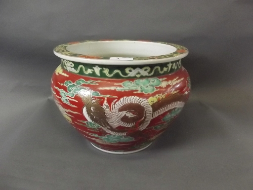 A large C19th Japanese pottery jardinière, red ground with dragons etc, 11½'' diameter, 9'' high