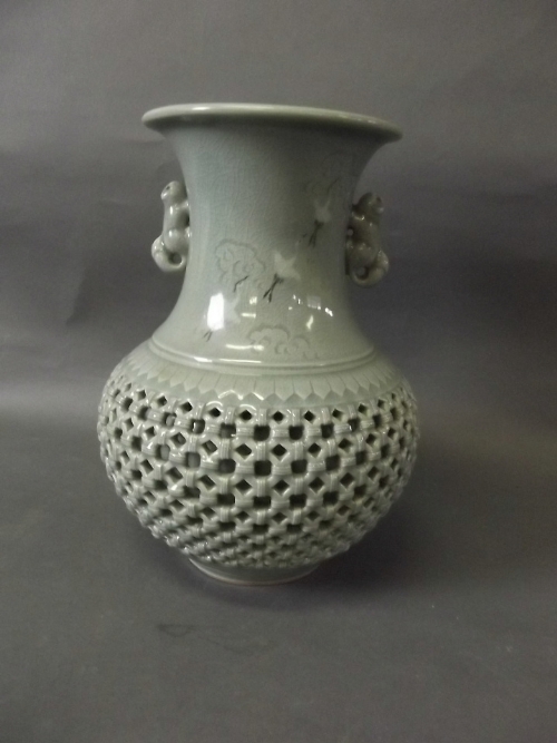 A Korean reticulated celadon glazed twin handled vase painted with cranes, signed, 9¼'' high