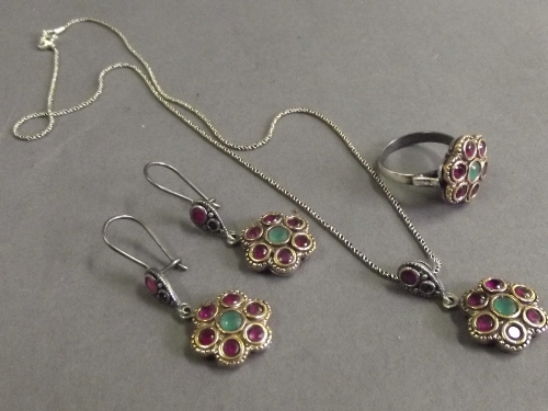 A silver and gilt necklace, ring, and earring garniture, set with rubies and emeralds, ring size O