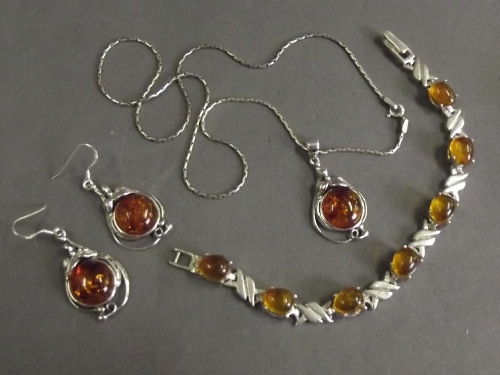 A silver necklace with silver and amber style set pendant, a matching pair of earrings and bracelet