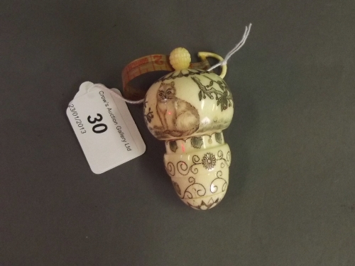 An engraved and turned bone thimble case and combined tape measure, decorated with a cat, 3'' high