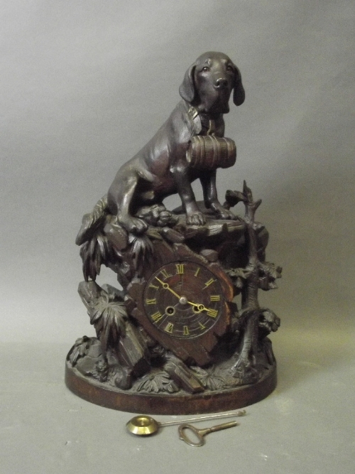 A C19th Black Forest mantle clock, carved with leaves beneath a seated St. Bernard dog with a barrel