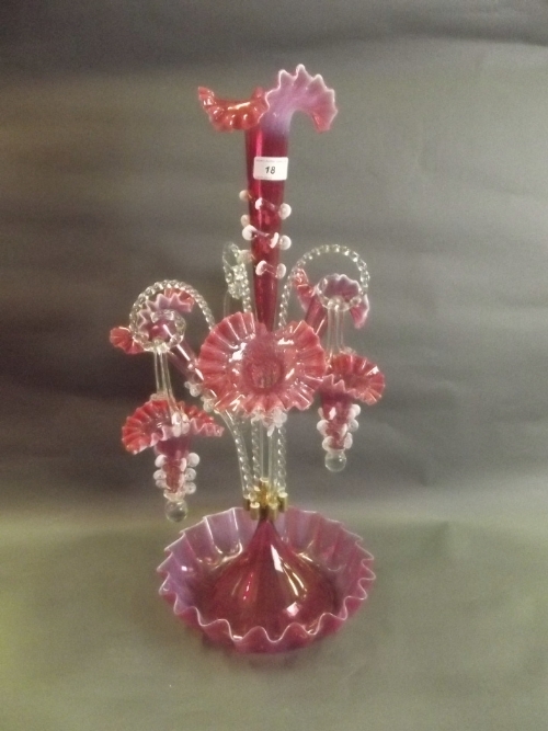 A large Victorian style cranberry coloured glass table epergne with hanging baskets and frilled