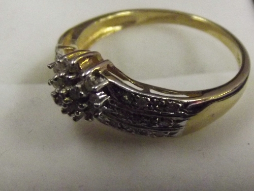 A 9ct gold ladies ring with diamond cluster on 3 diamond set bands, size R