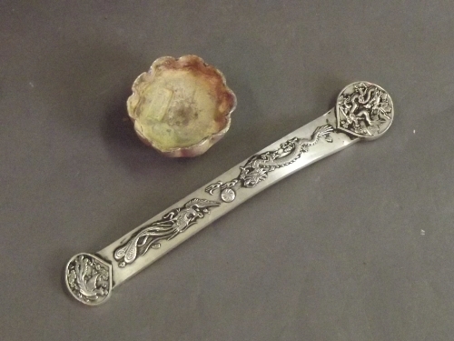 A silvered metal trade token, and another in the form of a ruyi, 8" long