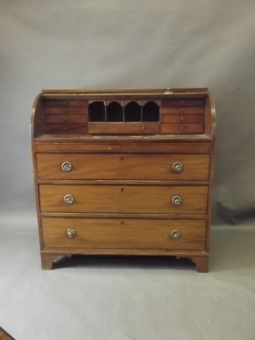 A C19th mahogany cylinder topped bureau with fitted interior and reading slope over 3 long