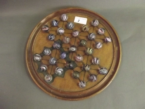 An early C20th mahogany solitaire game with original marbles, 11'' diameter